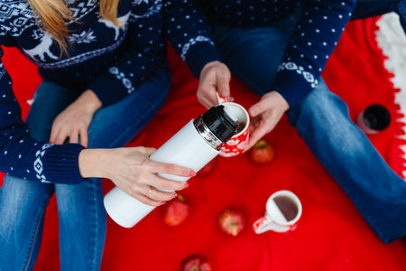 Girl pours tea in a mug with a picture of the heart.の写真素材