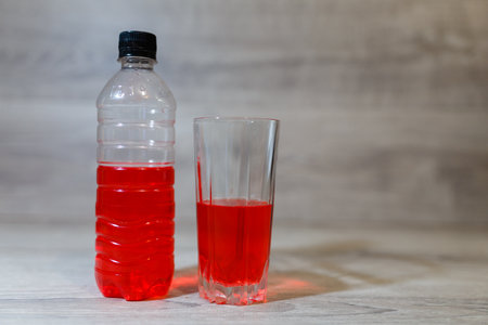 Sports set, energy drink in glass and plastic bottle on wooden table, pill box. Energy for workout...