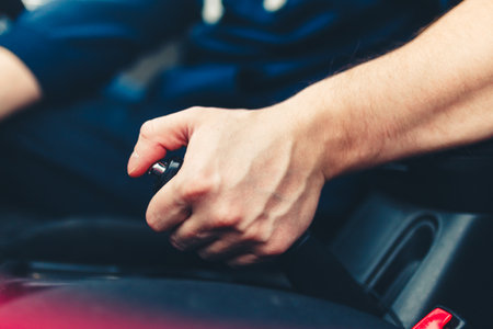 The driver pulls the hand brake lever. Male hand pulling the Parking brake using the hand brake lever.の写真素材