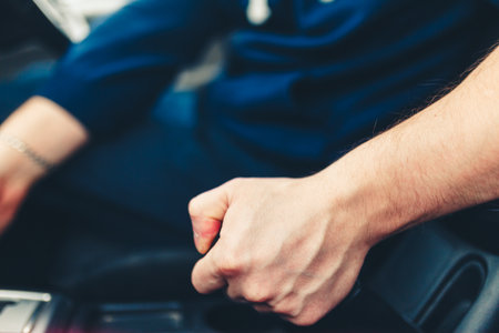 The driver pulls the hand brake lever. Male hand pulling the Parking brake using the hand brake lever.の写真素材