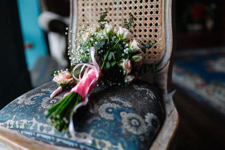 Bouquet of flowers and boutonniere on an old chair. Wedding bouquet of fresh flowers on a chair, close-up, loft style.の写真素材