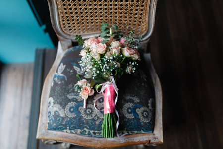 Bouquet of flowers and boutonniere on an old chair. Wedding bouquet of fresh flowers on a chair, close-up, loft style.の写真素材