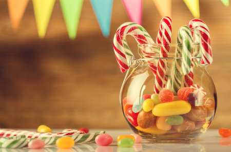 Colored candy in a jar. Sweets for Christmas. Greeting card. Candy canes. Marmalade. Retro toning.の写真素材