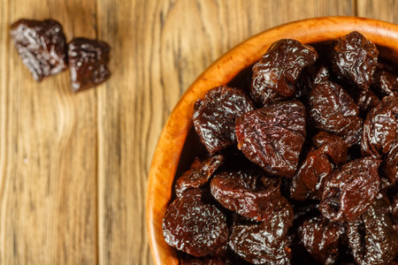 Prunes in a bowl made of beech. Place for text. Dietary food.の写真素材