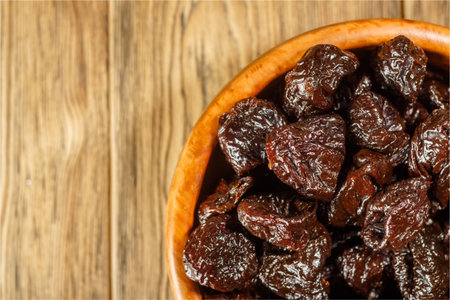 Prunes in a bowl made of beech. Place for text. Dietary food.の写真素材