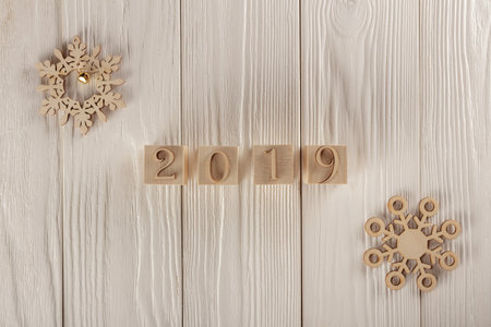 Christmas card, wooden cubes on a wooden background. Home cozy design. Happy new year 2019.の写真素材