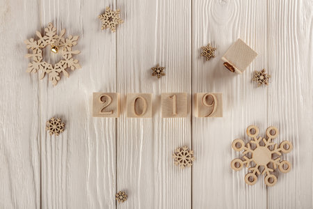 Christmas card, wooden cubes on a wooden background. Home cozy design. Happy new year 2019.の写真素材
