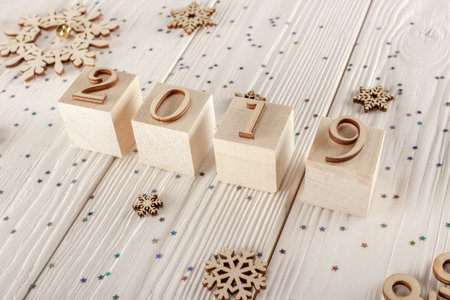 Christmas card, wooden cubes on a wooden background. Home cozy design. Happy new year 2019.の写真素材