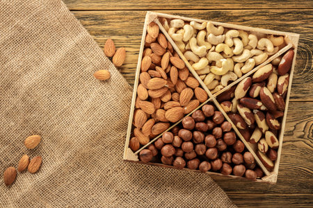Assorted nuts. Set of nuts top view. Wooden table, rustic style. Place for text. Vegetarian set.の写真素材