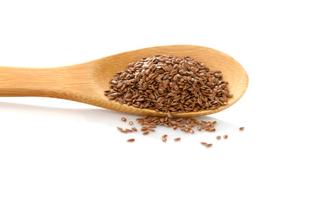 Flax seed. Linen in wooden spoon on white isolated background.の写真素材