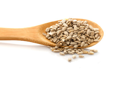 Peeled sunflower seed in a spoon. Isolated on white background. In raw form, you can eat.の写真素材