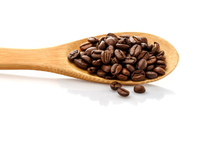 Coffee beans in spoon. Roasted coffee beans. On a white background isolated.の写真素材