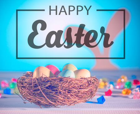 happy Easter. The Easter Bunny, a nest with eggs. Tinted effect. Blue background.の写真素材