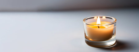 Burning candle in a glass on a white background, close-upの素材