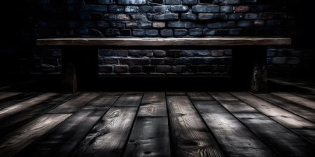 Old wooden table and brick wall in a dark room. Toned.の素材