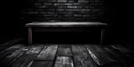 Old wooden table with black brick wall in dark room. Toned.の素材