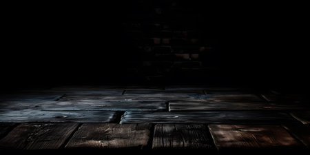 Wooden table in a dark room with copy space. Black background.の素材