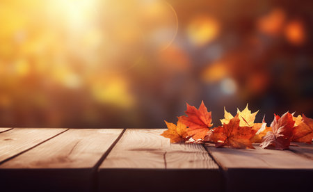 Wooden table with autumn leaves on bokeh background. Autumn backgroundの素材