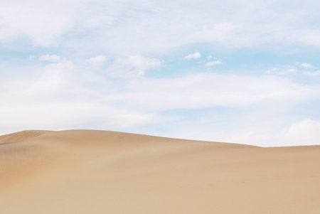 Clean background with sand dune and blue skyの写真素材
