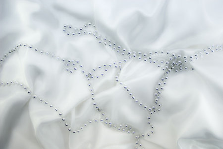 Silver beads on white silkの写真素材