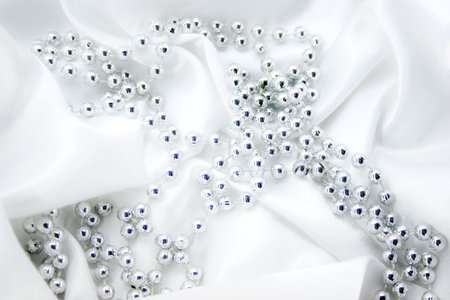 silver beads on white silkの写真素材