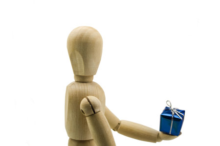 Wooden dummy with a gift in handsの写真素材
