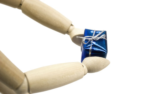 Gift in hands of a wooden dummyの写真素材