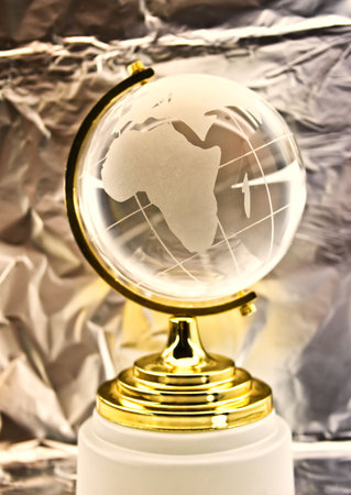 glass globe against ìåòàëè÷åñêîé a foilの写真素材