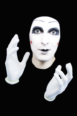 Portrait of the cheerful mime in white gloves on a black backgroundの写真素材