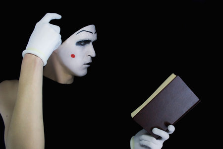 Portrait of the reading mime with the book on a black backgroundの写真素材