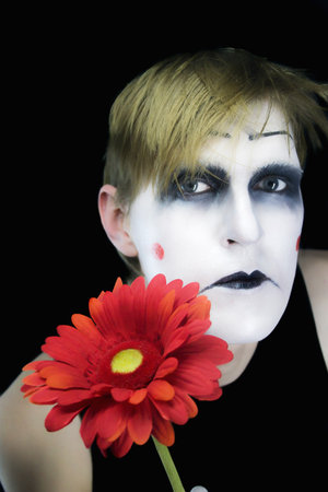 gloomy mime with a red flower on a black backgroundの写真素材