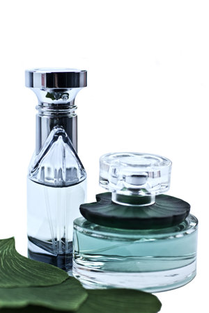 bottles of perfume with the leaves on a white background