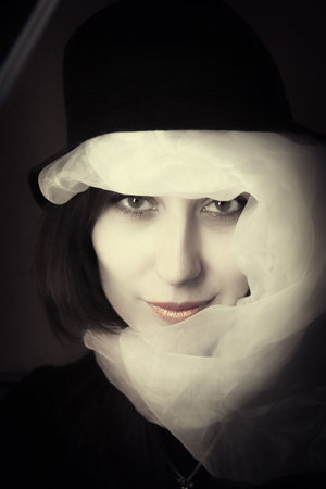Portrait of  young brunette of the woman in  hat and  scarfの写真素材