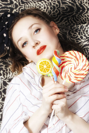 Portrait of young woman with a sugar candy close upの写真素材