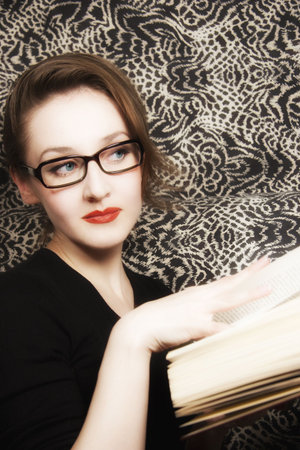 Portrait of  young beautiful woman in glasses with  bookの写真素材