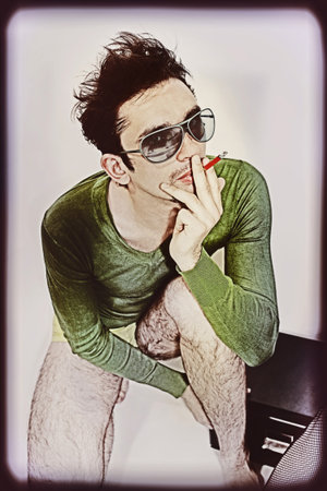 Portrait of a young guy with a cigarette in sunglassesの写真素材