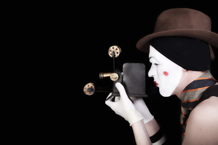 portrait of mime in white gloves and brown hat with cameraの写真素材