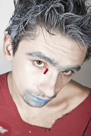 Face of a young guy with blue lips and bloody tearsの写真素材