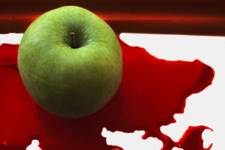 fresh green apple in a pool of red blood