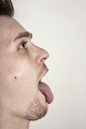 guy with mouth wide opened showin tongueの写真素材