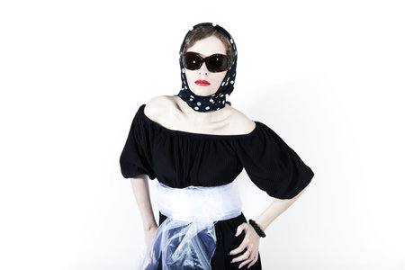 Young stylish woman wearing headscarf and sunglasses on white backgroundの写真素材