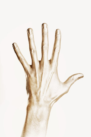 beautiful man's hand in gold paint isolated on white backgroundの写真素材