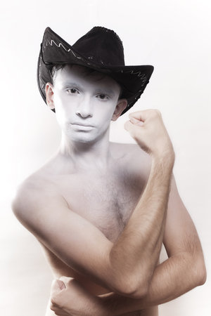 Portrait of young naked man in cowboy hat isolated on white backgroundの写真素材