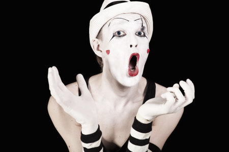 Ape mime in striped gloves and white hat on black backgroundの写真素材