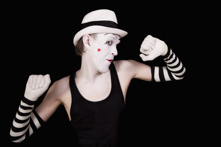 Ape mime in striped gloves and white hat on black backgroundの写真素材