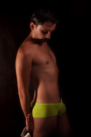 young handsome guy in green shorts and white hat on black background
の写真素材