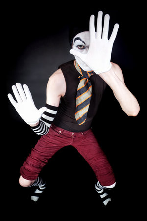 Funny mime in white gloves on black backgroundの写真素材