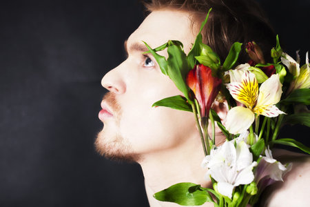 Portrait of a young man with a bouquet of flowersの写真素材