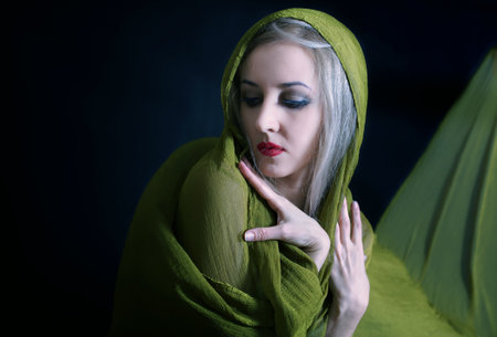 Gentle studio portrait of beautiful young woman in green summer dressの写真素材