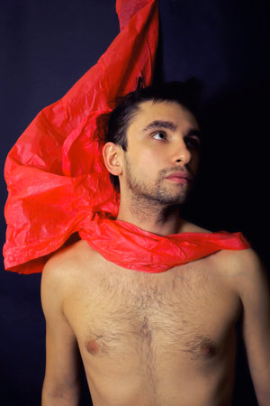 handsome young man in a red scarf with a stylish hairdoの写真素材